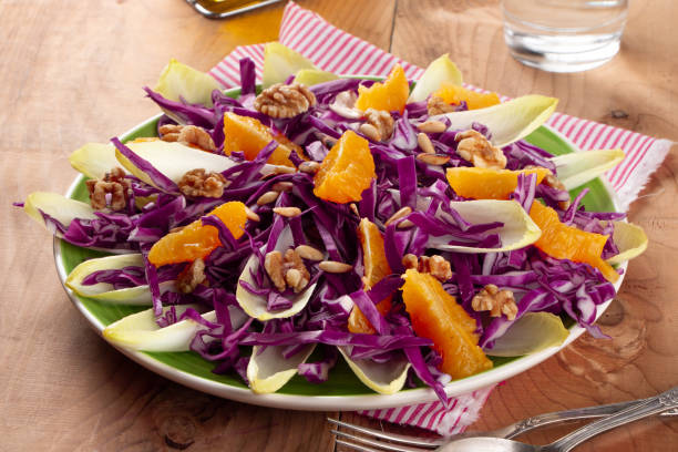 bunter rotkohlsalat mit endivie und orangenfrüchten - pine nut nut seed vegan food stock-fotos und bilder