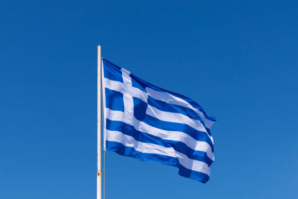 istock Greek national flag againts blue sky 1365421855