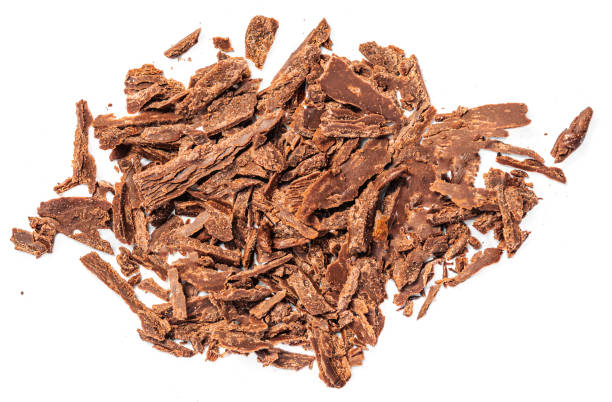 istock Grated Chocolate pieces isolated on white background. Crushed dark chocolate Top view. Creative layout