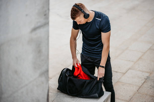 istock Young Man Packing A Gym Bag After A Workout 1365425035