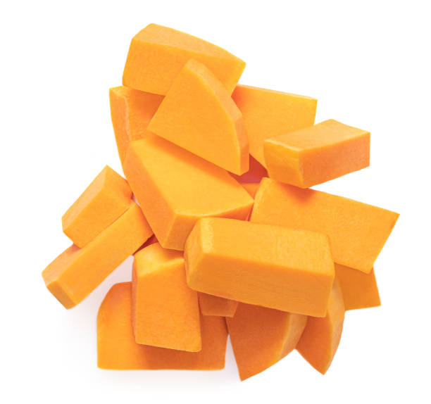 istock Sliced pumpkin pieces  isolated on white background. Diced Pumpkin cubes. Top view. Flat lay