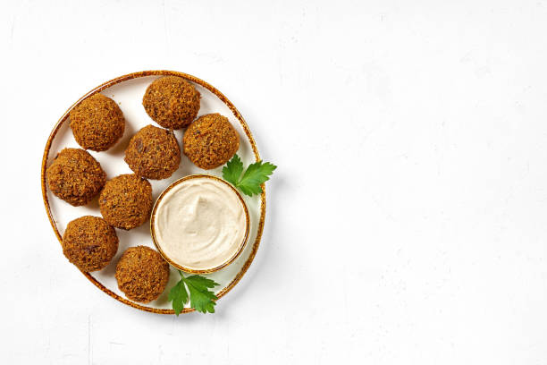 Plate of chickpeas falafel with tahini sauce isolated on white background. Top view, copy space Chickpea, Falafel, Food, Hummus savory food photos stock pictures, royalty-free photos & images