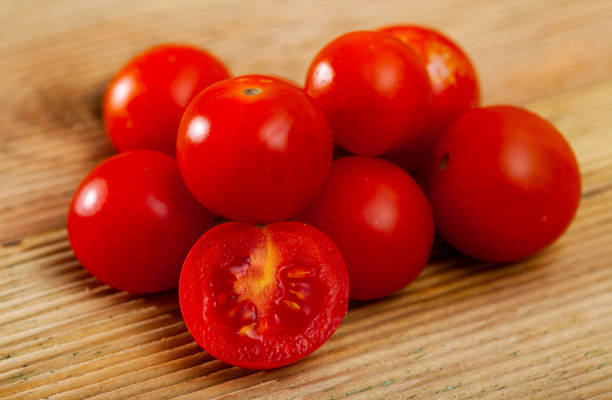 istock Whole fresh red cherry tomatoes on wooden table. Vegetarian ingredient 1365427045