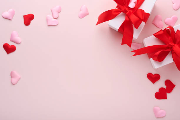 istock White gift boxes with red ribbon and small red decorative hearts on pink background. Top view with copy space. Valentines day or Wedding romantic concept. Festive composition. Mock up. 1365427067