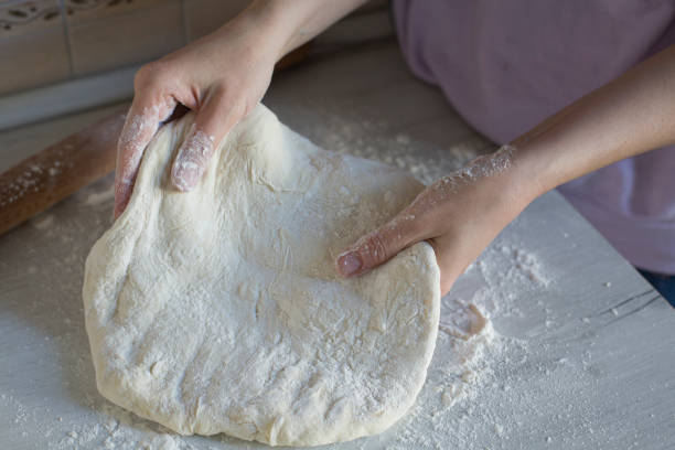 istock Homemade cooking close up. Making dough by hands 1365431016