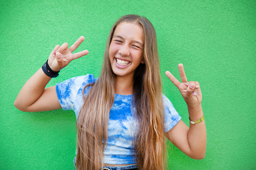 Portrait of happy pre-teen girl on green background