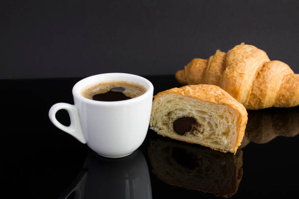istock Close-up on coffee cup and croissant with chocolate on the dark background 1365431946