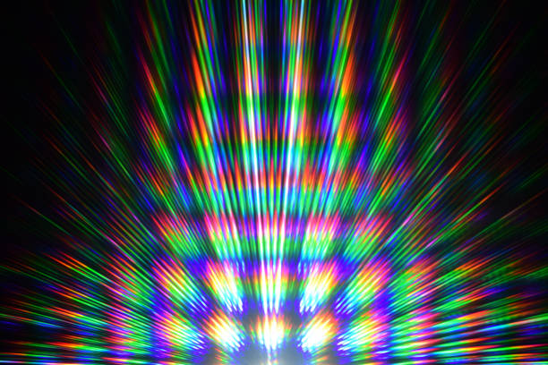 The white light passing through the two diffraction gratings of the RGB filter creates regular geometric rays in red, green and blue with rainbow passages. explosión de color de rayos de luz blanca a la vista a través de dos rejillas de difracción de un filtro rgb. un arco iris de colores. rayos arco iris. imágenes de difracción. luz de prisma. fondo negro. imagen abstracta. experimento de luz. llama de