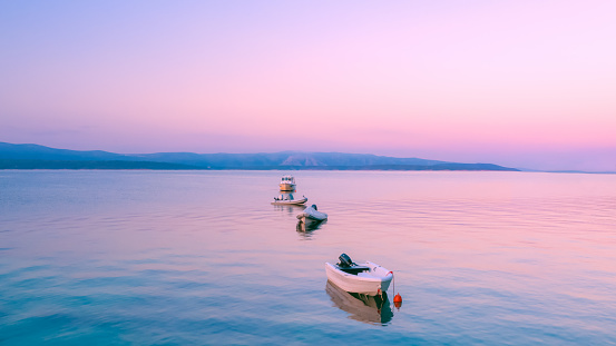Boats at sunrise. Pink sunrise in the sea. Four boats parked in a row.