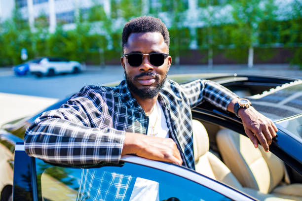 istock Stylishly dressed young African man and luxury vehicle 1365436014