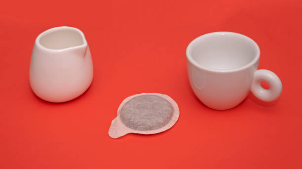 istock Espresso cup and pod on red background 1365436091