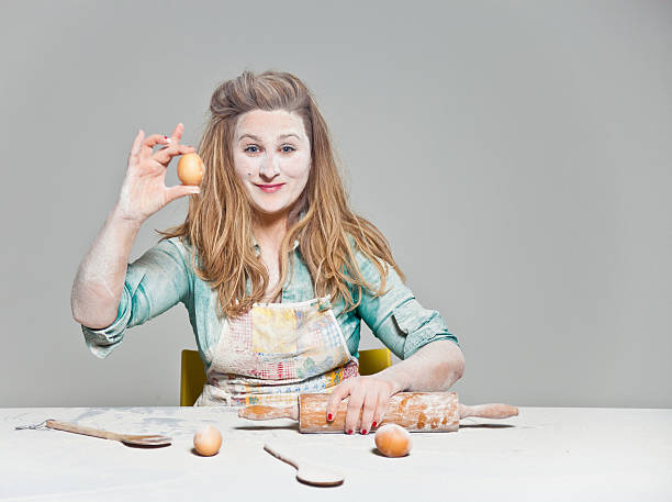 hausfrau mit eiern - stereotypical housewife women domestic kitchen brown hair stock-fotos und bilder