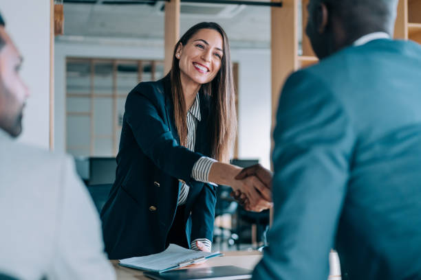 Successful partnership Business people shaking hands in the office. Group of business persons in business meeting. Three entrepreneurs on meeting in board room. Corporate business team on meeting in modern office. Female manager discussing new project with her colleagues. Company owner on a meeting with two of her employees in her office. transparent stock pictures, royalty-free photos & images