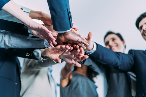 Shot of multi-ethnic group of business people with stacked hands showing unity and teamwork. Successful business people stacking hands in the office.