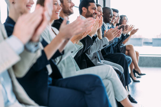 Businesspeople applauding during a seminar in conference hall. Shot of a group of cheerful business persons applauding during a seminar. this side is for address only stock pictures, royalty-free photos & images