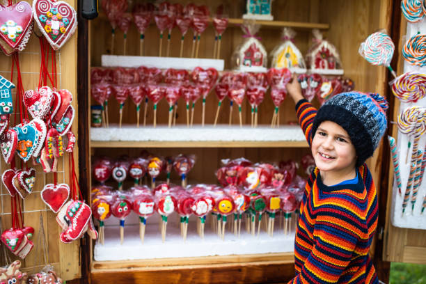 A cute boy is asking for a gingerbread house at the  Christmas market