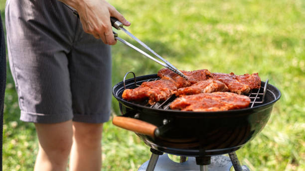 istock Young man frying meat on the grill 1365438336