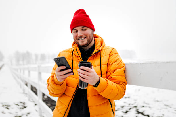 istock Man rests with hot coffee for a long walk through the snowy nature 1365439624