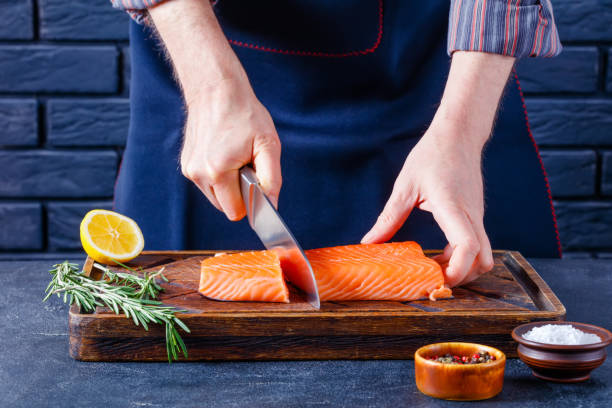 istock Man is cutting salmon fillet., top view 1365439677
