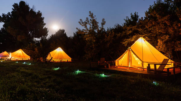 Glamping at night, few glowing tents Glamping at night, few glowing tents, nightlights glamping photos stock pictures, royalty-free photos & images