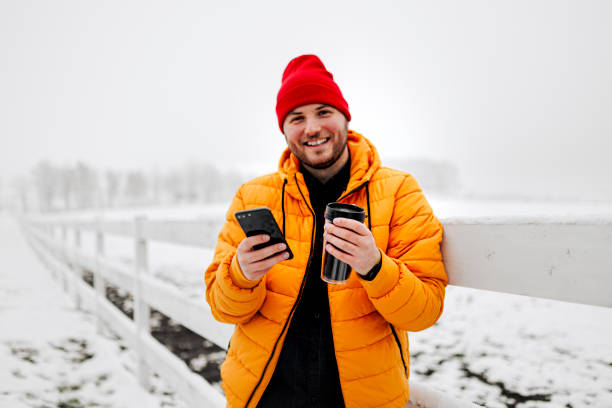 istock Man rests with hot coffee for a long walk through the snowy nature 1365439911