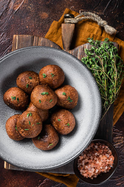 istock Vegetarian meatless Meatballs from plant based meat with herbs. Dark background. Top view 1365439921