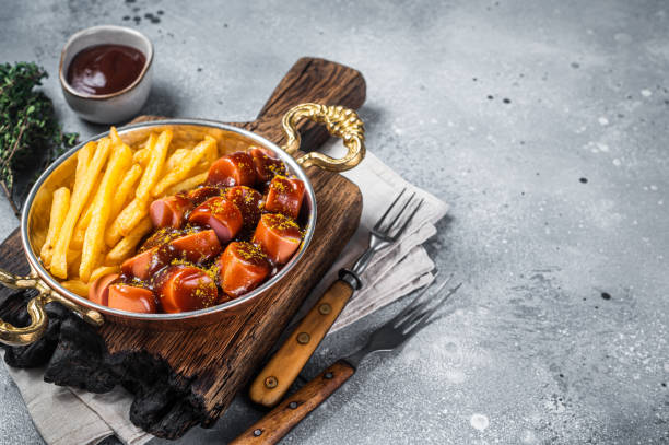 traditionelle deutsche currywurst, serviert mit pommes frites oder pommes frites in der pfanne. grauer hintergrund. draufsicht. speicherplatz kopieren - currywurst stock-fotos und bilder