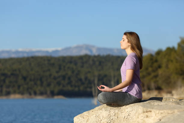 istock Young woman doing yoga exercise in nature 1365443892