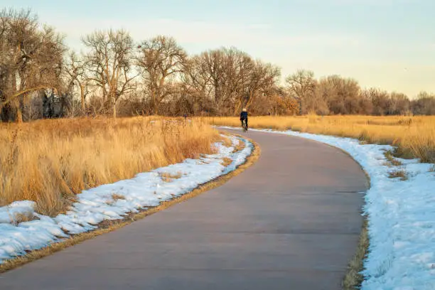 typical winter sunset scenery on a bike trail in Fort Collins, Colorado, with a distant cyclist and walkers