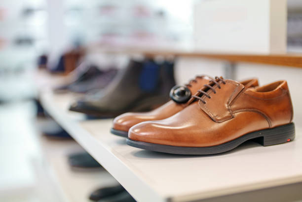 istock Cognac-colored leather men's shoes in a shoe store. 1365447740