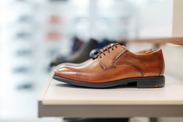 istock Cognac-colored leather men's shoes in a shoe store. 1365447765