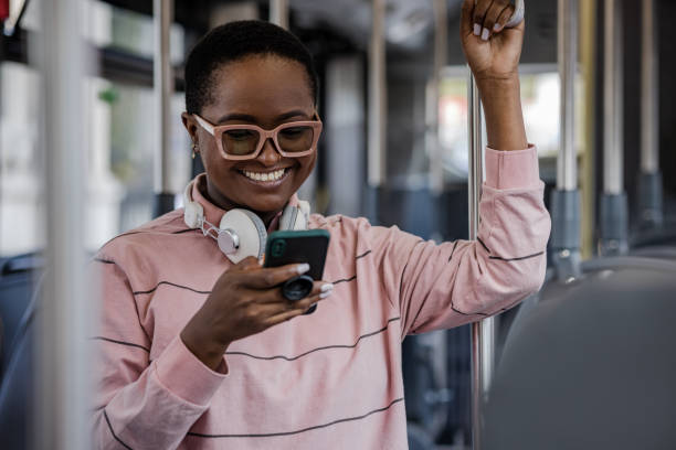 istock Cheerful woman using smart phone in the bus 1365449675