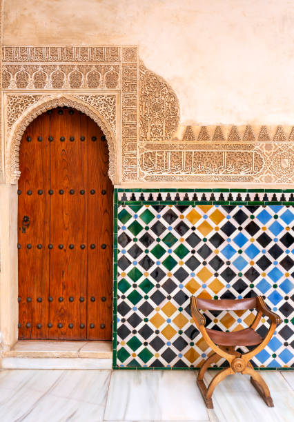 Amazing detail in Alhambra, Spain. Amazing detail in Alhambra, An old wooden door with an ancient Nasrid's pattern carving on stone wall , Spain - Andalusia granada spain stock pictures, royalty-free photos & images