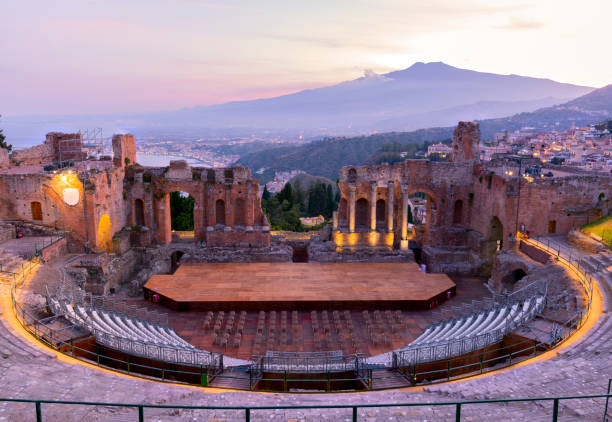 sonnenuntergang auf dem antiken römisch-griechischen amphitheater mit der bucht giardini naxos im hintergrund in taormina, sizilien, italien - ätna stock-fotos und bilder