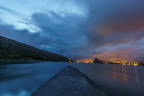クロアチアのクルク島につながる背景に橋を持つ夜の桟橋 - sailboat pier bridge storm ストックフォトと画像