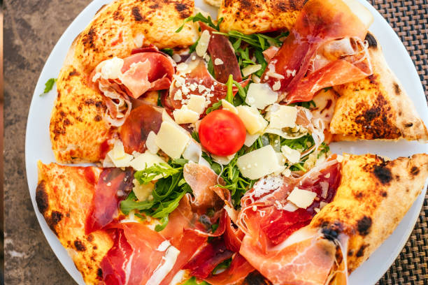 istock Delicious Italian pizza with prosciutto and arugula 1365456043
