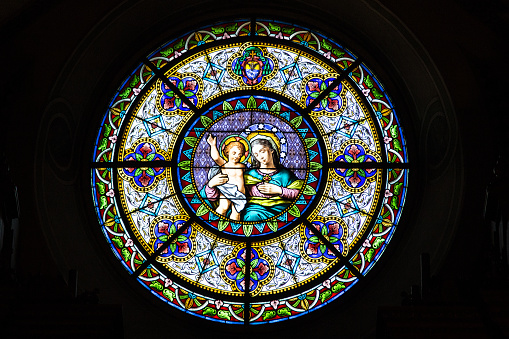 Lugao, Switzerland - January 14, 2022: The famsous Cathedral of Saint Lawrence in Lugano and its stained glass rosette of Virgin Mary with baby Jesus, Lugano, Switzerland