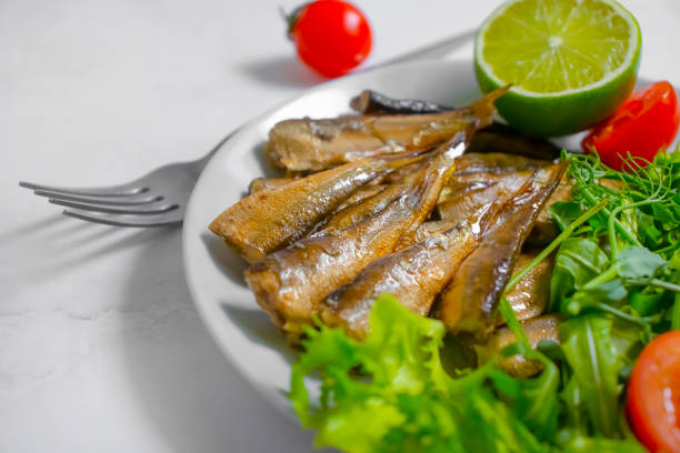 sprats on a plate, greens tomato