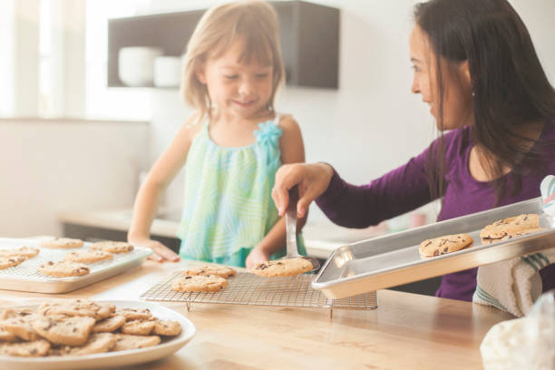 istock Mixed Race mother and daughter baking cookies in a light modern kitchen 1365458812
