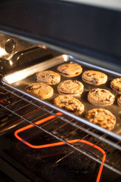 Chocolate Chip cookies baking in an oven stock photo