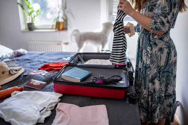 istock Young women packing her suitcase in bedroom 1365459482