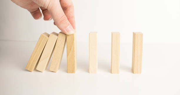 istock Businesman stops hands falling over domino to stop risk continuously, Continuous damage reduction, Stop business domino failures concept. 1365460134