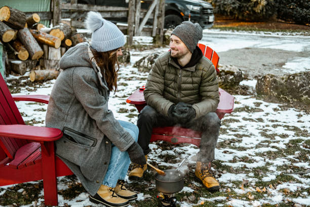 istock Young couple making hot chocolate drink outdoors 1365460352