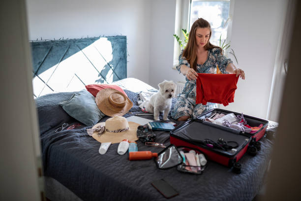 istock Young woman packing clothes in suitcase for vacation 1365461204