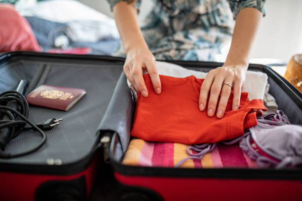 istock Woman preparing summer luggage for vacation 1365461831