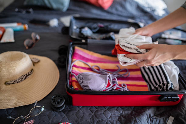 istock Woman hand packing clothes for vacation 1365463001