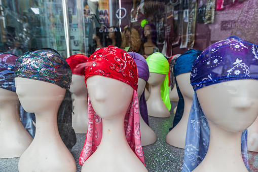 The Bronx, New York City, New York, USA. Head scarves on mannequin heads in a store window.