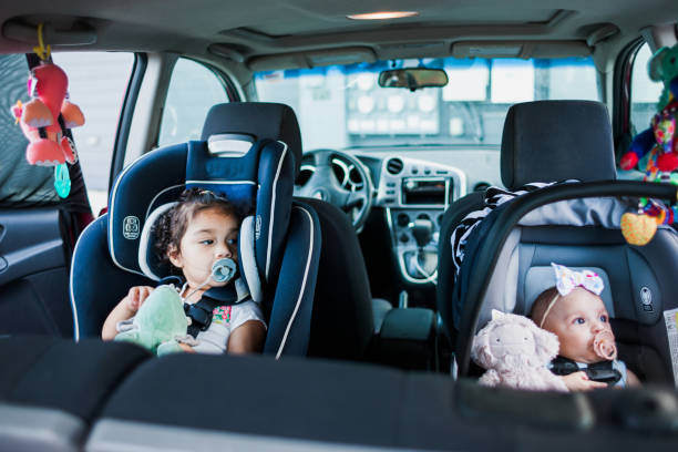 istock Mother Buckling Her Babies Into Carseats for Roadtrip 1365468310