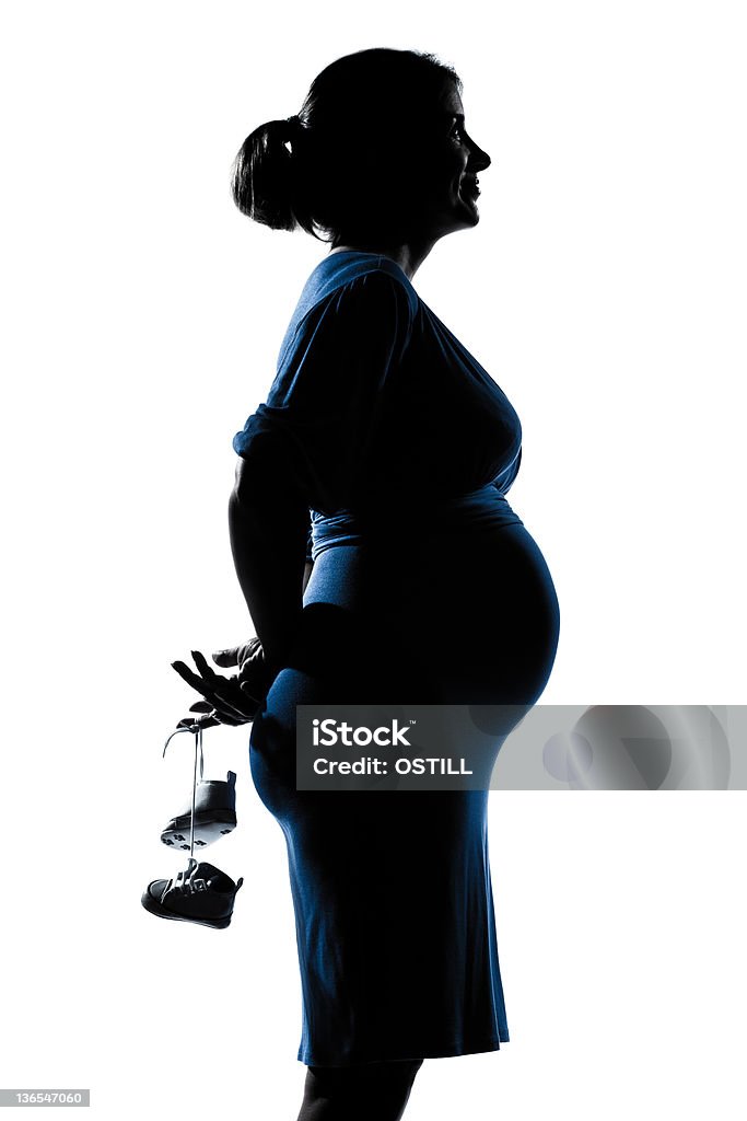 portrait de femme enceinte femme tenant des Chaussures de bébé - Photo de Profil libre de droits