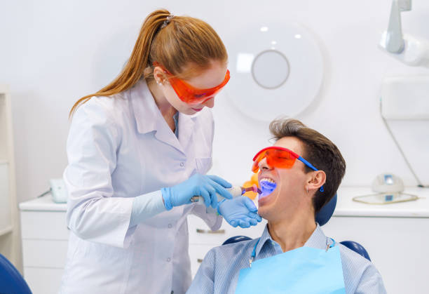 istock Dentist curing teeth of patient with light 1365471756